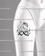 Cherry heart tattoo stencil shown on female thigh with heart-shaped cherries, gothic flames, sparkle accents, leaf detail, and bold Y2K fruit tattoo design