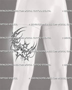 Cyber tribal moon tattoo stencil shown on men’s thigh with crescent moon, sharp star details, ornamental linework, and chain accent