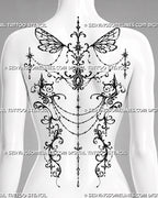 Feminine ornamental back tattoo shown as a women’s backpiece with gothic fairy wings, symmetrical filigree, draped chains, jewel details, and pendant accents