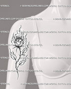 Fire rose tattoo shown on the front of a woman’s upper arm with flaming petals, a long thorned stem, branching leaves, and black-and-grey detail