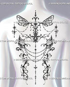 Gothic fairy wing tattoo shown across a woman’s upper and mid back with mirrored filigree, central jewel details, chains, and open negative space
