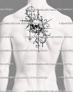 Gothic ornamental skull tattoo shown at the center of a man’s upper back with structured filigree, dark shading, hanging diamonds, and sharp vertical details