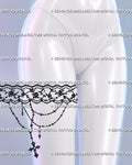 Lace thigh garter tattoo shown on a woman’s upper thigh with floral lace, scalloped borders, draped bead chains, and a hanging gothic cross pendant
