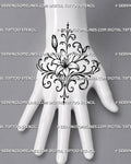 Lily hand tattoo stencil shown on the back of the hand with a central open flower, two buds, mirrored filigree curls, and pointed ornamental accents