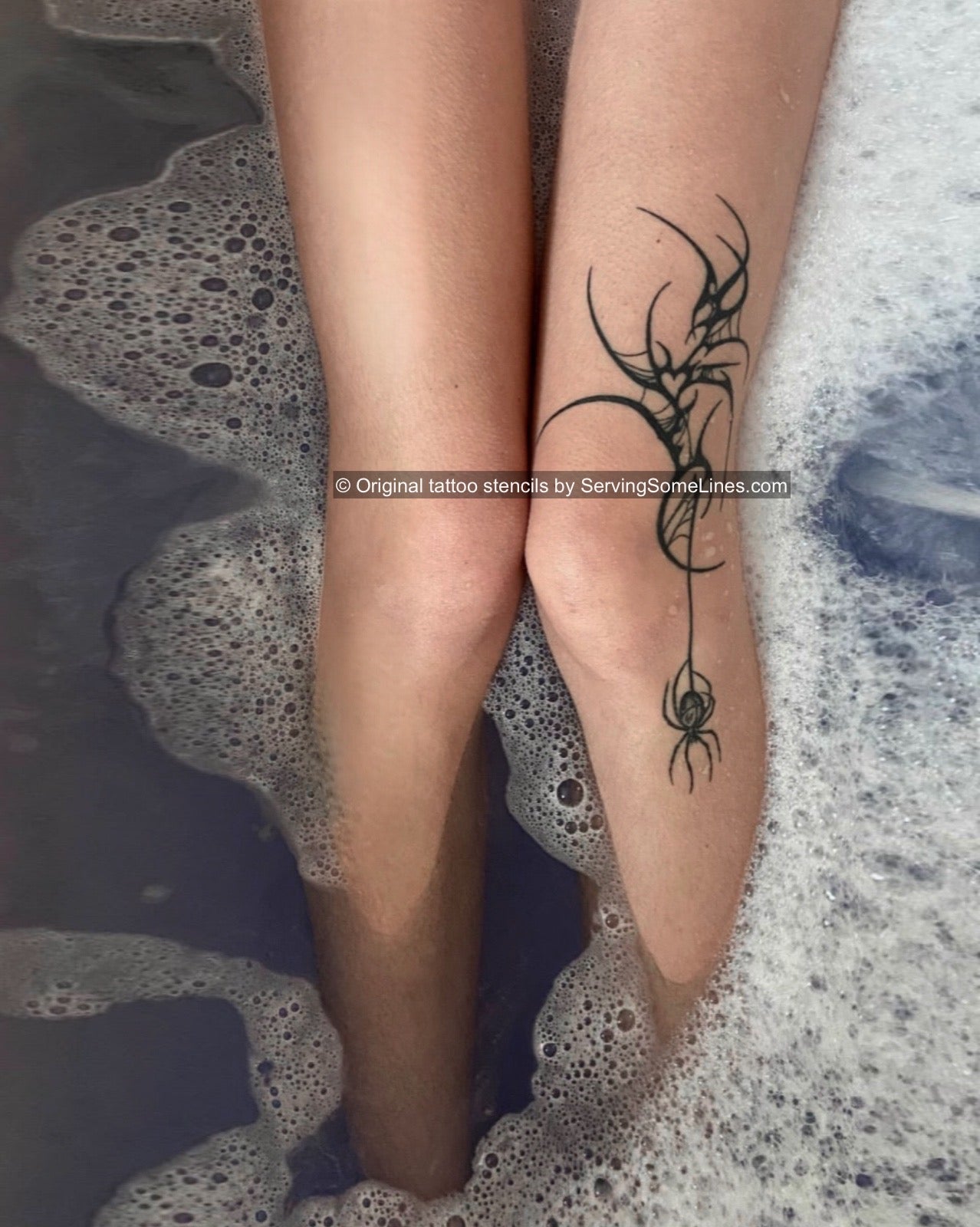 Neotribal spiderweb side knee tattoo in black tribal linework with abstract spider silhouette and small heart element in the web