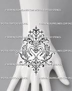 Ornamental swan heart tattoo shown on the hand with two mirrored swans, detailed wing feathers, pointed stars, curling flourishes, and a centered heart composition
