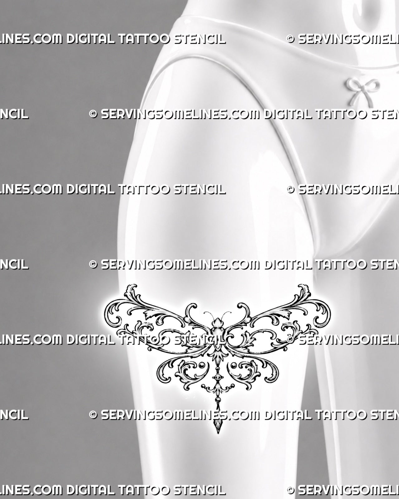Ornate dragonfly tattoo shown on the front of a woman’s thigh with wide acanthus filigree wings, baroque curls, and jewelry-inspired pendant details