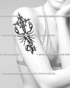 Ornate scorpion key tattoo shown on women's arm, with sharp claws, gothic key top, and a wrapped vertical scorpion shape