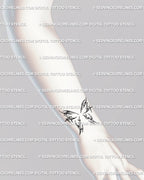 Small butterfly wrist tattoo idea in cybercore fine-line style, subtle feminine micro tattoo with ornamental soft curves