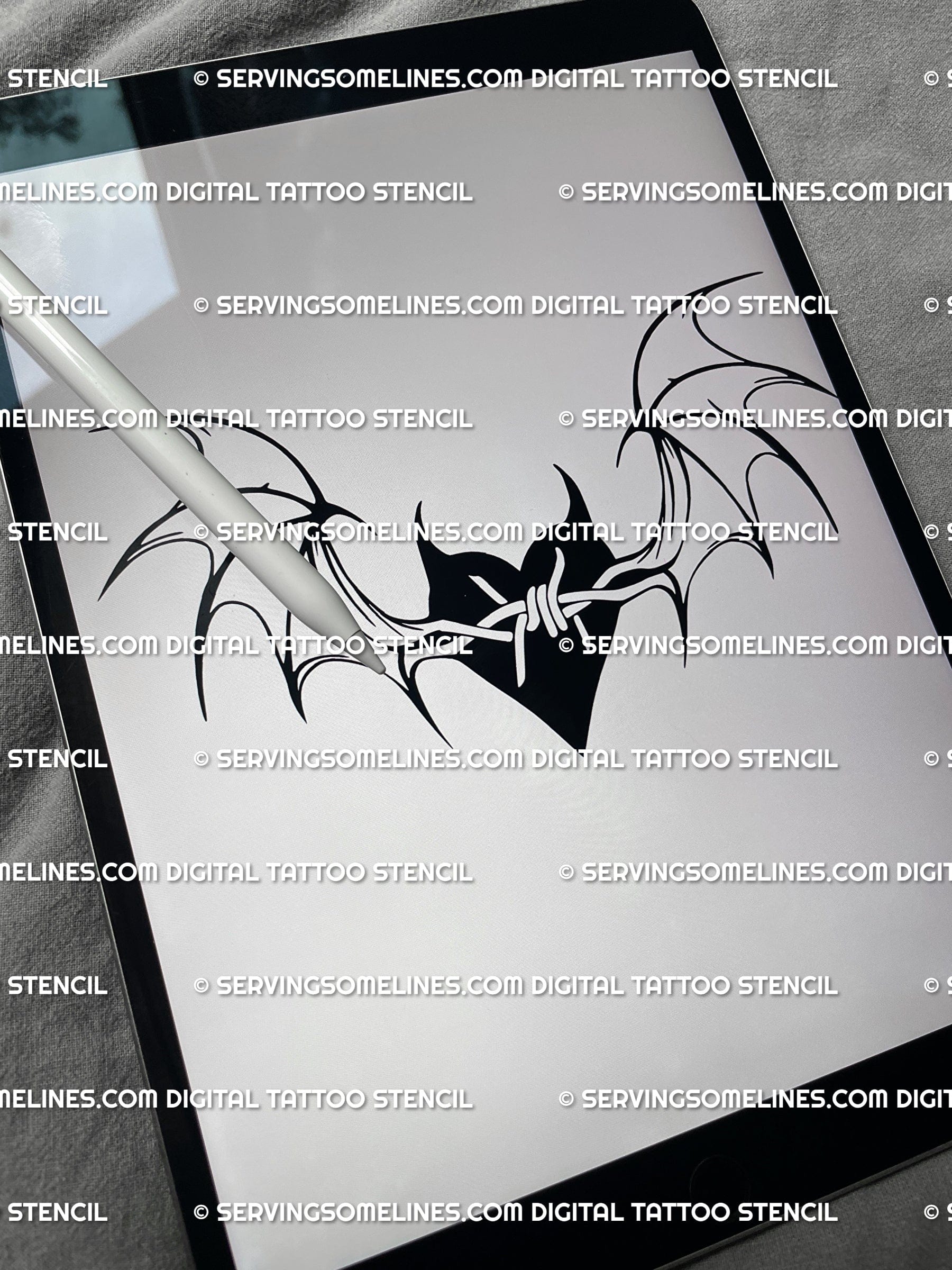 Digital bat wings heart tattoo stencil file on iPad, gothic heart with barbed wire wings and clean black line design. 