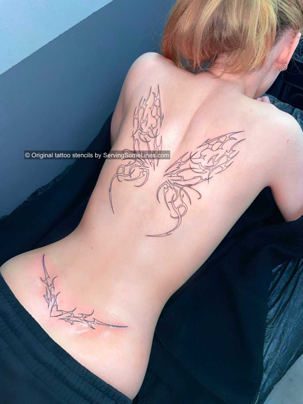 Fairy wings and lower back tramp stamp tattoo done with original ServingSomeLines stencils, clean linework and balanced flow