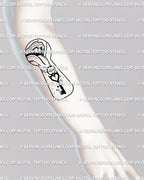 Keyhole tattoo design shown on the forearm as a digital stencil preview with lips and tongue imagery in fine linework made for clear vertical placement