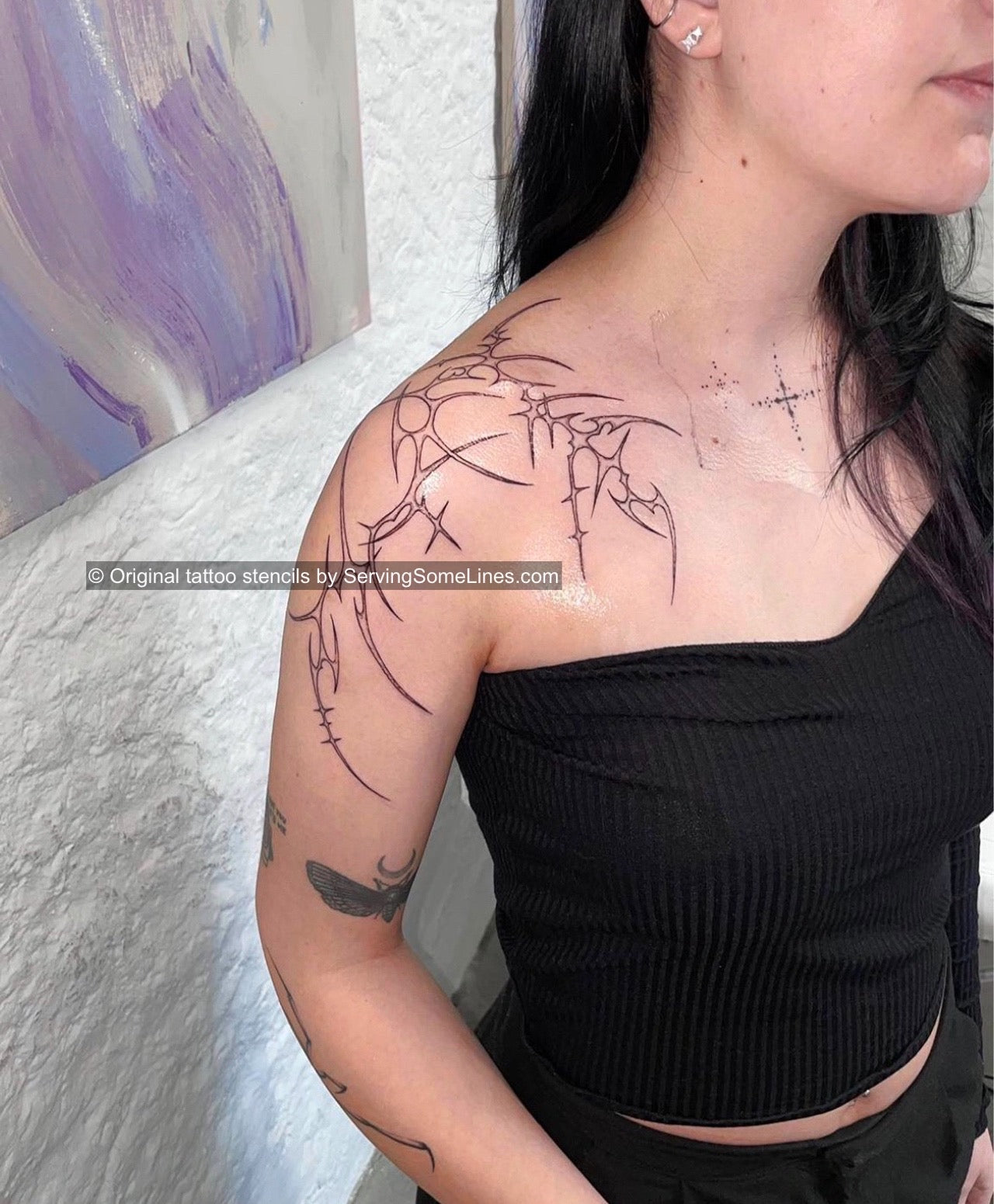 Female shoulder tattoo with neotribal spiky outline and delicate heart detail, light ornamental cyber-tribal design project