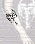 Winged skull key tattoo stencil shown on forearm placement, cybersigilism edge, spiked wing frame, chain charm, clean transfer lines.